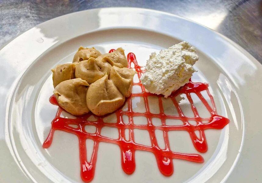 Dessert plate with peanut butter dollops, whipped cream, and strawberry sauce drizzle.